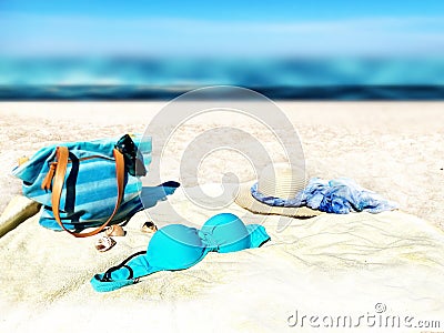 Eautiful beach with white sand turquoise ocean water and blue sky women bag and bikini hat with blue bow accessories on sand Stock Photo