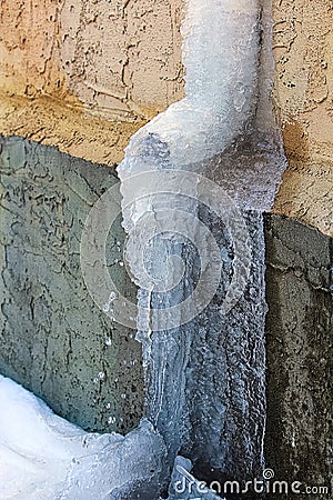 An eavestrough covered in ice and spring runoff water Stock Photo