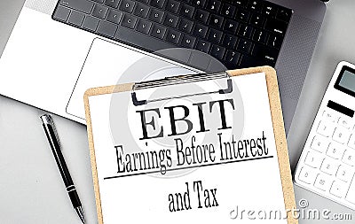 EBIT word on clipboard on laptop with calculator and pen Stock Photo