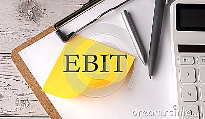 EBIT word on yellow sticky with calculator, pen and clipboard Stock Photo