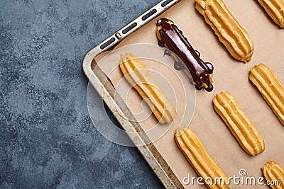 Eclairs or profiterole with chocolate and whipped cream preparing Stock Photo