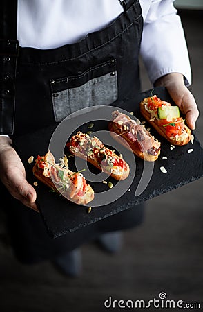 Eclairs with salmon, fresh vegetables and herbs, gourmet snacks. Stock Photo