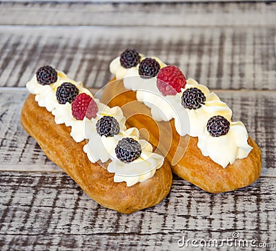 The eclairs with vanilla cream cheese decorated with fressh berries Stock Photo