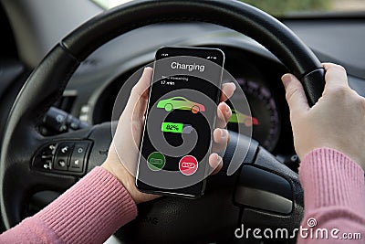 Eco electric car women hand holding phone with charging battery Stock Photo