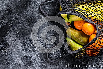 Eco friendly reusable shopping string bag, filled with fruits. Eco friendly, plastic free. Black background. Top view. Copy space Stock Photo