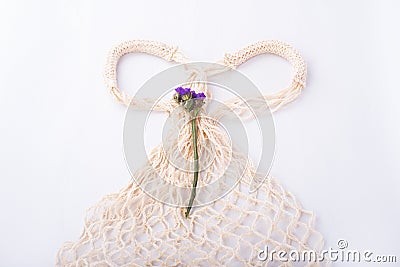 Eco friendly string bag and blue flower on white background, responsible consumption. zero waste concept. Stock Photo