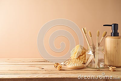 Eco friendly toothbrush and soap dispenser on wooden table over beige background Stock Photo