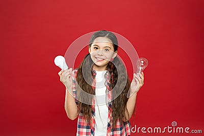 Eco life. Lighting choice. Little girl light bulbs on red background. Symbol of idea progress and innovation Stock Photo