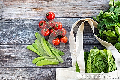 Eco Shopping Bag with fresh organic vegetables and salad on wooden background, Flat Lay Stock Photo