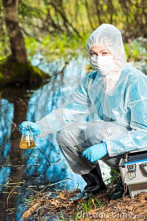 ecological catastrophe - the ecologist is taking a sample of water in a flask from a forest Stock Photo