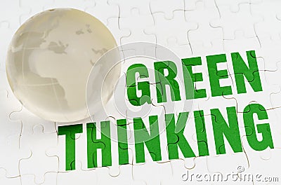 On white puzzles there is a glass globe and the inscription - Green Thinking Stock Photo
