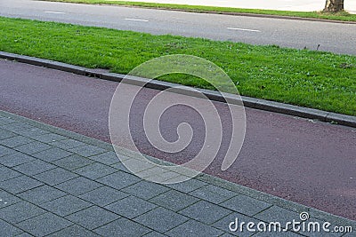 Ecological infrastructure. Sidewalk next to bicycle lane next to green strip and car road Stock Photo