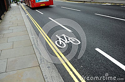 Cycle lane with bicycle symbol on the streets of London, UK and red bus. Stock Photo