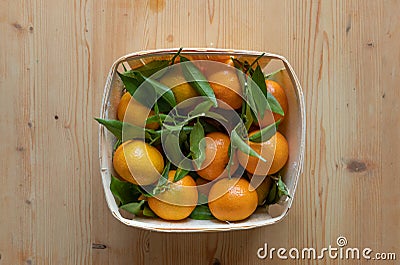 Ecological tangerine basket on a light wooden base Stock Photo