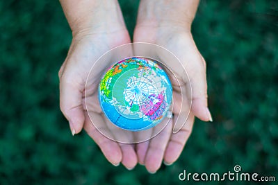 Ecology. Environmentally friendly planet.Woman holding planet model on green background, earth day concept Stock Photo