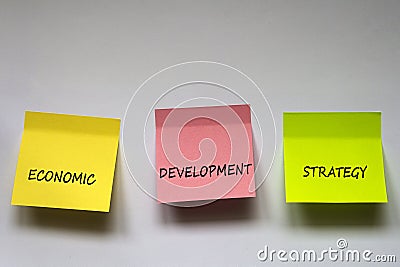 `Economic development strategy`, the phrase is written on multi-colored stickers on white background. Stock Photo