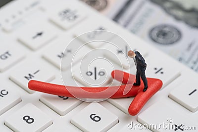 Economic recession, bear stock market or financial crisis concept, miniature businessman standing on red pointing down arrow on Stock Photo