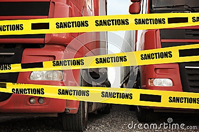 Economic sanctions. Trucks on road in front of barrier tape Stock Photo