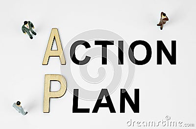 On a white background, figures of businessmen, wooden letters and the inscription - ACTION PLAN Stock Photo