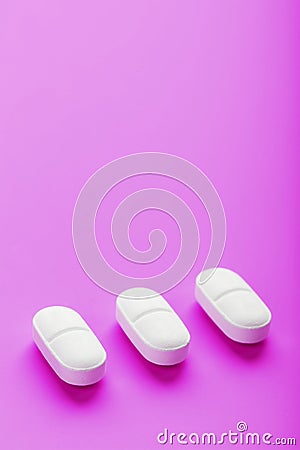 Ecstasy pills in a row on a pink background, isolate. Stock Photo