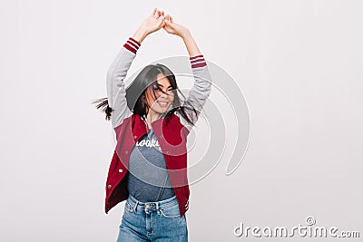 Ecstatic brunette asian woman with charming smile dancing with hands up, enjoying photoshoot. Cheerful young lady with Stock Photo