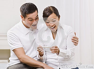 Ecstatic Couple Looking at a Pregnancy Test