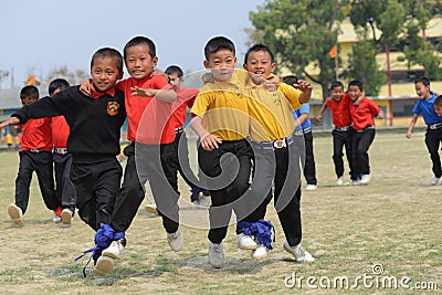 Ecstatic school students competing in three legged race Editorial Stock Photo