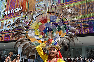 Ecuadorian folklore dancer is posing with a big decorative wheel feather ornamental hat on her head in a sunny summer day. Editorial Stock Photo