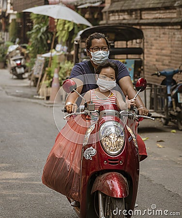 ED-Bankgok, Thailand - 2019-30-13 - Mother and Daughter Ride Motorcycle With Face Masks Editorial Stock Photo