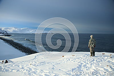 On the edge of the earth, north of Russia, the Arctic Ocean shore. Contrast of overall nature and small man. Beautiful snowy view Stock Photo