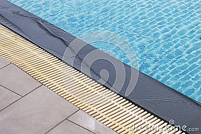 The edge of the pool is made of granite with a sieve for overflowing water Stock Photo