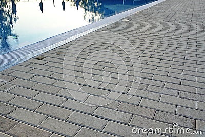 Edge Of Swimming Pool With Reflection And Concrete Paving Stock Photo