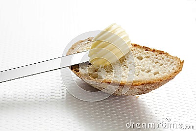 Edge of white bread with curl of butter, close up. Stock Photo