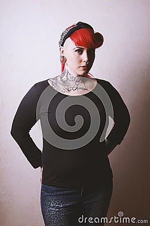 Edgy portrait of a young woman with many facial piercings and ta Stock Photo