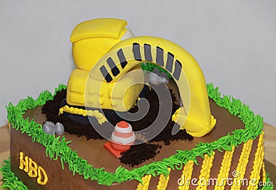 Edible Alloy Excavator Truck Car Vehicles and pile of soil with traffic cone on the chocolate cake. And text HBD Stock Photo