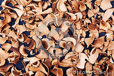 Edible dried mushrooms background close up top view, dry boletus edulis dark texture, chopped brown cap boletus wallpaper, sliced Stock Photo