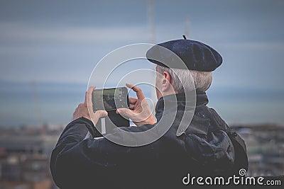 Edinburgh, UK - February 10, 2018. Tourist man taking panoramic pictures in Edinburgh, Scotland Editorial Stock Photo
