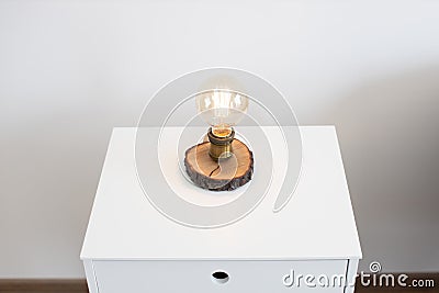 Edison lamp on bedside table near sofa in studio room Stock Photo