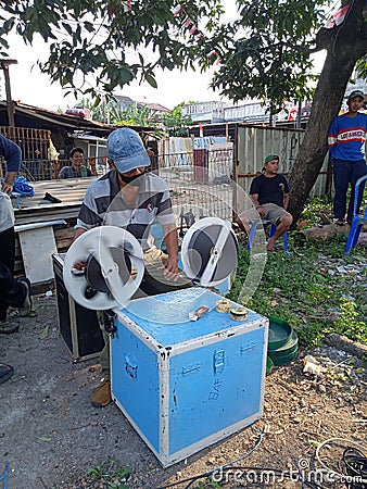 Editorial photo, indonesia, 20 august 2022, east jakarta man rewinding celluloid film, analog movie, prepare for layar tancap Editorial Stock Photo