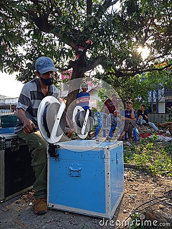 Editorial photo, indonesia, 20 august 2022, east jakarta man rewinding celluloid film, analog movie, prepare for layar tancap Editorial Stock Photo