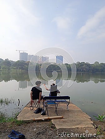 Editorial Photo, Indonesia, East Jakarta, Cibubur, 08 August 2021, Man Fishing at Lake Editorial Stock Photo