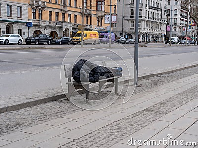 Man sleeping on a bench at the sidewalk Editorial Stock Photo