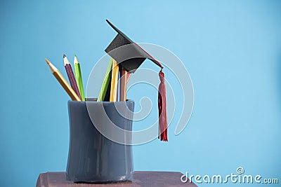 Education and back to school concept with graduation cap pencils color in a pencil case on blue background Stock Photo