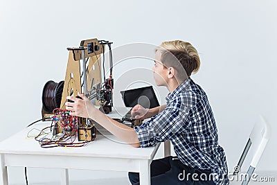 Education, children, technology concept - teen boy is printing on 3d printer. Stock Photo