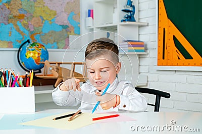 Education, elementary school, kids learning concept. School kids with pens and notebooks writing test in classroom Stock Photo