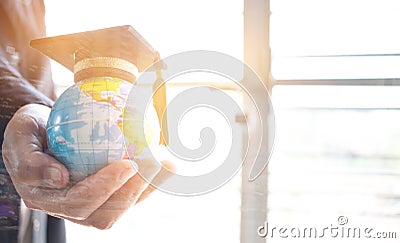 Education in Global, Graduation cap on Businessman holding Earth Stock Photo