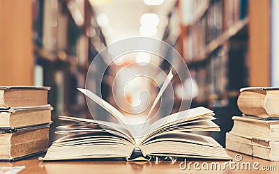 Education learning concept with opening book or textbook in old library, stack piles of literature text academic archive Stock Photo