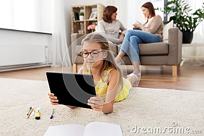 Girl with tablet computer lying on floor at home Stock Photo