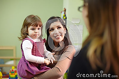 Educator and mother with little girl at school Stock Photo