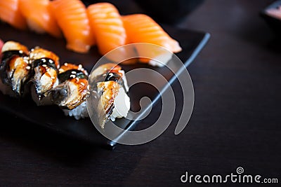 Eel and salmon sushi sashimi on black dish with empty table Stock Photo